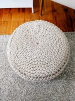 Round beige crocheted pouf